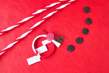 日本の正月イメージ　 紅白の水引リースと紅白の水引の紐と黒と金の水引結び（赤バック）