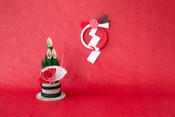 日本の正月イメージ　扇のついた門松と紅白の水引リース（赤バック）