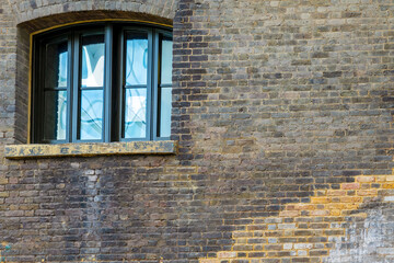 Window with reflection in an old brick wall