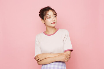 Obraz premium スポーティなファッションをした若い女性のピンク背景のポートレート
