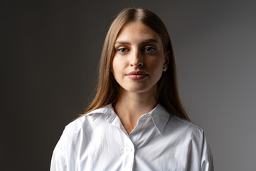 Thoughtful businesswoman portrait on a dark gray background