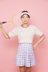 スポーティなファッションをした若い女性のピンク背景のポートレート