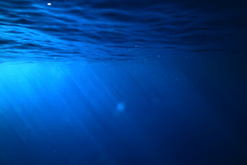 ocean underwater rays of light background, under blue water sunlight