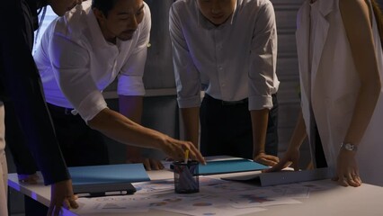 A group of businesspeople share their ideas to expedite the completion of the project until late at night.