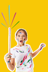 very excited little child girl in colorful paint holding brush in one hand