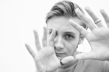 Young man covering his face with his hands from an attack