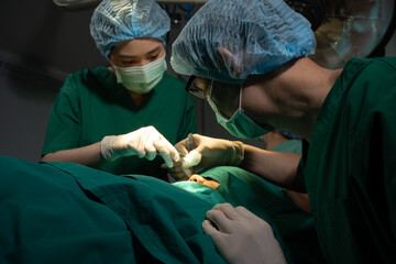 Asian Professional surgeons team performing surgery in the operating room, surgeon, Assistants, and...