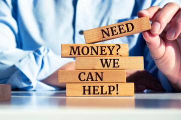 Wooden blocks with words 'Need Money? We Can Help!'.