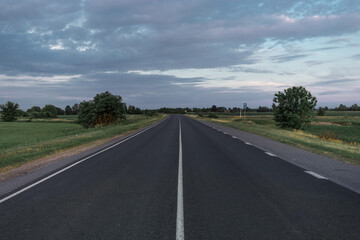 Asphalt road going into the distance on a summer evening