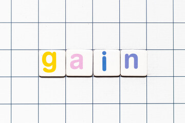Colorful tile letter in word gain on white grid background