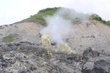 Fumarole emitting smoke, fume and sulphur steam in mountain valley at Tamagawa Onsen Hot spring in...