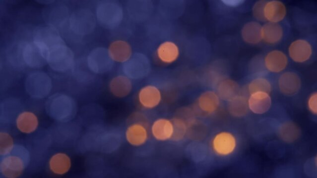 Abstract blurred glowing golden lights in slow motion. Blue bokeh Christmas and New Year background.