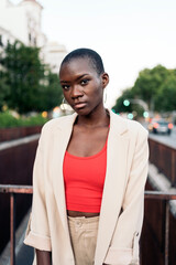 Portrait of an african american young woman standing and looking at camera on a footbridge in the city