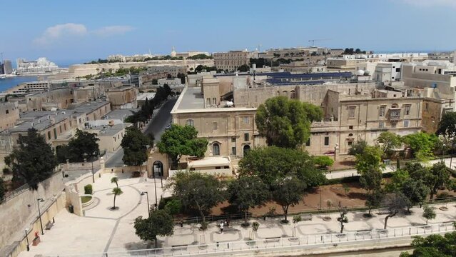 Revealing aerial drone view of Argotti Botanic Garden fortifications with  Valletta in background in Floriana, Malta