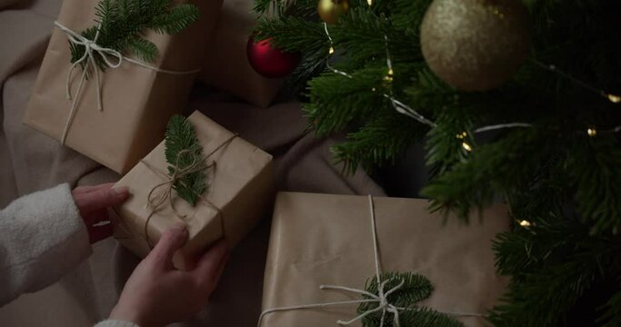 Traditional Christmas Presents Wrapped In Eco-Friendly Kraft Paper, Decorated With Strings And Natural Foliage. slow motion
