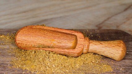 kitchen and cooking: a small wooden scoop spilled spices on the board