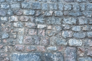 texture of a grey stone wall made of stones with concrete