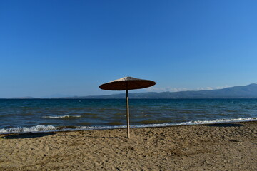 lonely umbrella on the coast of the sea on a clear morning
