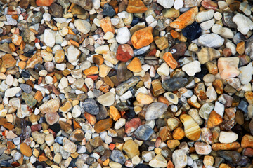 Blick von oben Draufsicht auf verschiedenfarbige Steine Kieselsteine im Wasser am Strand,...