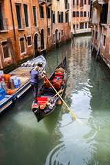 Fototapeta na wymiar People enjoying gondola ride in Venice, Italy