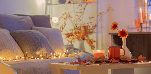 cup of tea and  autumnal leaves in cozy interior