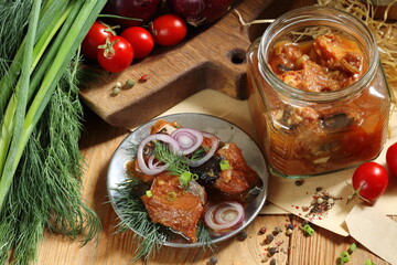 Fototapeta na wymiar Catfish canned in tomato on a wooden table in a glass jar