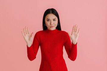 Asian young woman wearing sweater frowning and showing her palms