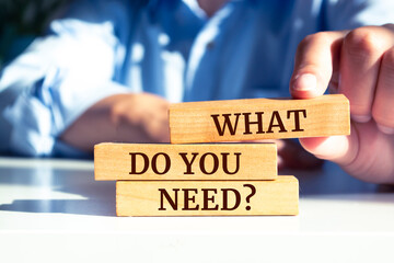 Wooden blocks with words 'WHAT DO YOU NEED?'.