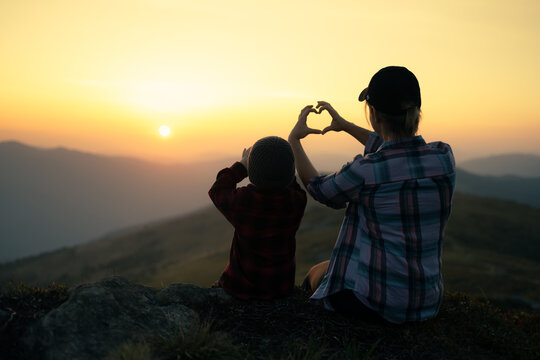 Mom with son in the autumn mountains during sunset. Travel with child concept