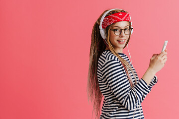 White woman with dreadlocks using cellphone while listening music