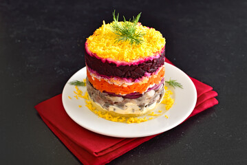 Layered salad with beet, herring, carrots and potatoes