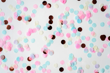 Blue and pink round confetti on white background. Festive day backdrop. Flat lay style with minimalistic design. Template for banner or party invitation