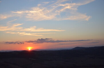 Sunset falling over the beautiful countryside and town of Montepulciano in Tuscany on a bright summer day