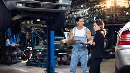 Asian young woman customer talking with owner and mechanic worker at car repair service and auto store shop.