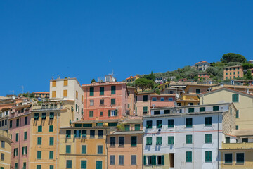 Fototapeta na wymiar Colorful residential buildings on a hillside with deep blue sky in the Itailian village of Camogli.