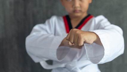 Asian boy clenching fists to practice taekwondo, Taekwondo martial art, selective focus detail on...