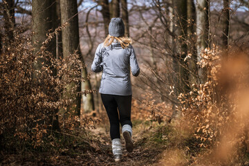 Fitness jogging in fall forest. Woman running outdoors. Sport activity