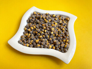 chickpeas Chennas in the plate with book and pen holder at the yellow background