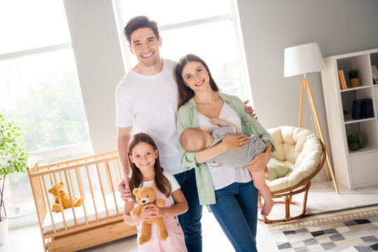 Photo of lovely idyllic people arms hold newborn cuddle toothy smile look camera house indoors