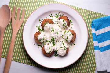 Pork meatballs with Greek tzatziki sauce with cucumber and yogurt. Traditional Greek recipe.