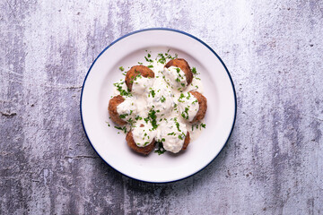 Pork meatballs with Greek tzatziki sauce with cucumber and yogurt. Traditional Greek recipe.