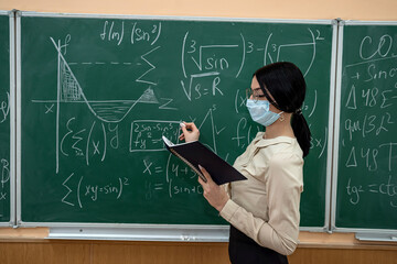 female teacher with mask learn math lesson at school during coronavirus pandemic