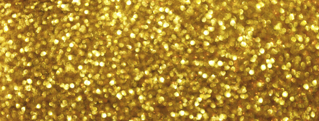 Blurred golden sparkling background from small sequins, macro. Shiny yellow glittery bokeh of...