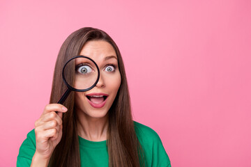 Portrait of sweet lovely pretty girl dressed green t-shirt hold magnifying glass on eye open mouth isolated on pink color background