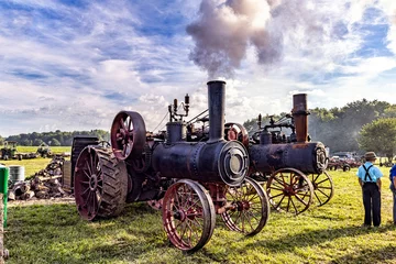 Schilderijen op glas Old Steam engine tractor with steam and smoke. © David Arment