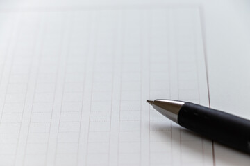 白の原稿用紙と黒のペン