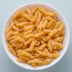 dish of raw pasta penne top view. penne pasta background. Carbo food, mediterranean diet, italian food.