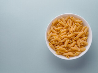 dish of raw pasta penne top view. penne pasta background. Carbo food, mediterranean diet, Food background.