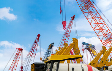 Crawler crane against blue sky. Real estate industry. Red crawler crane use reel lift up equipment...