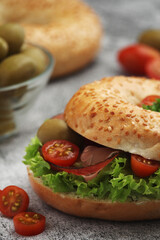 Sesame bagels with tomatoes, ham and olives